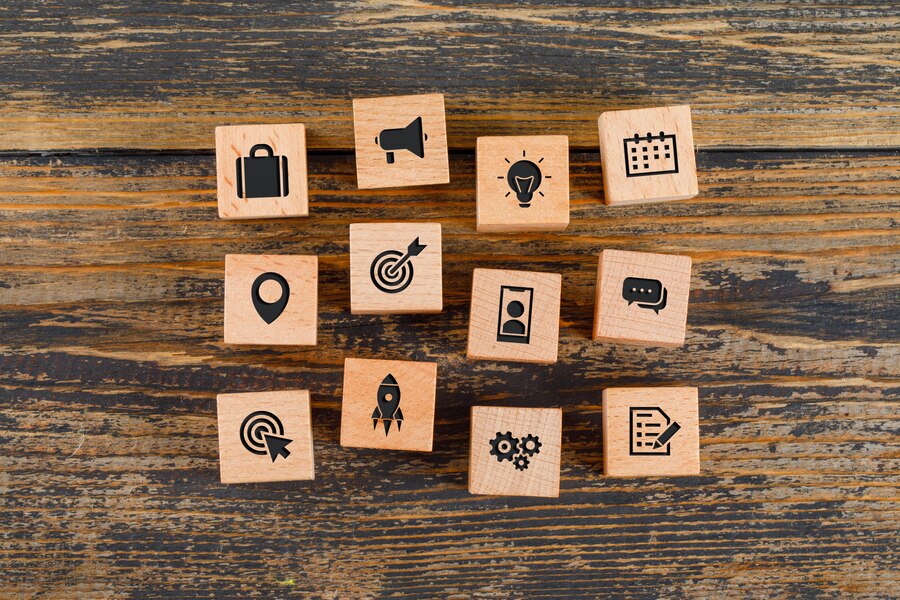 concepto-negocio-iconos-cubos-madera-mesa-madera-plana-lay_176474-9354